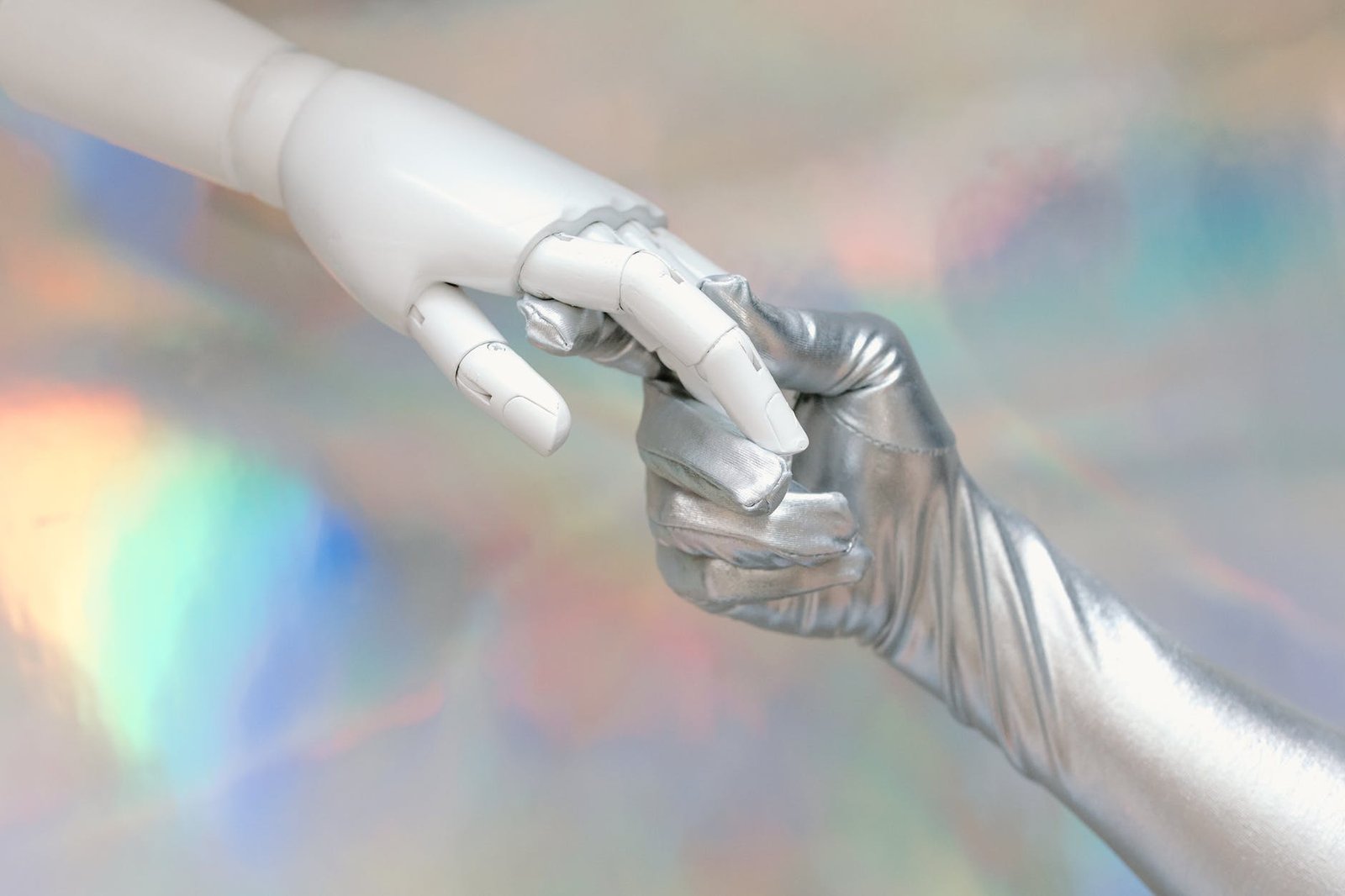 hand with silver glove holding a robot hand